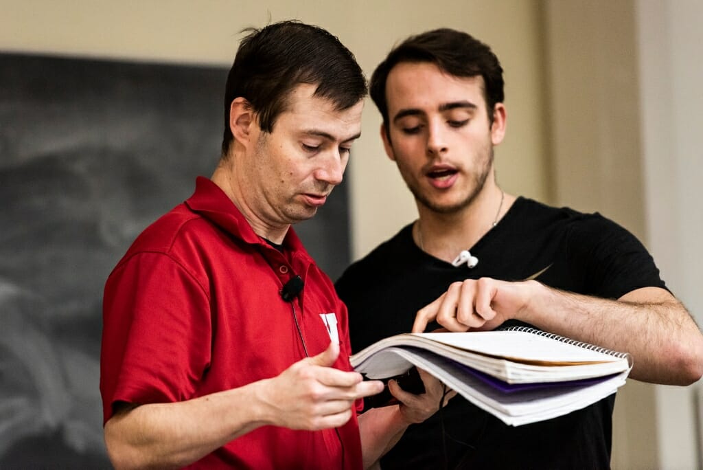 Photo: Student pointing at notebook Matt is holding