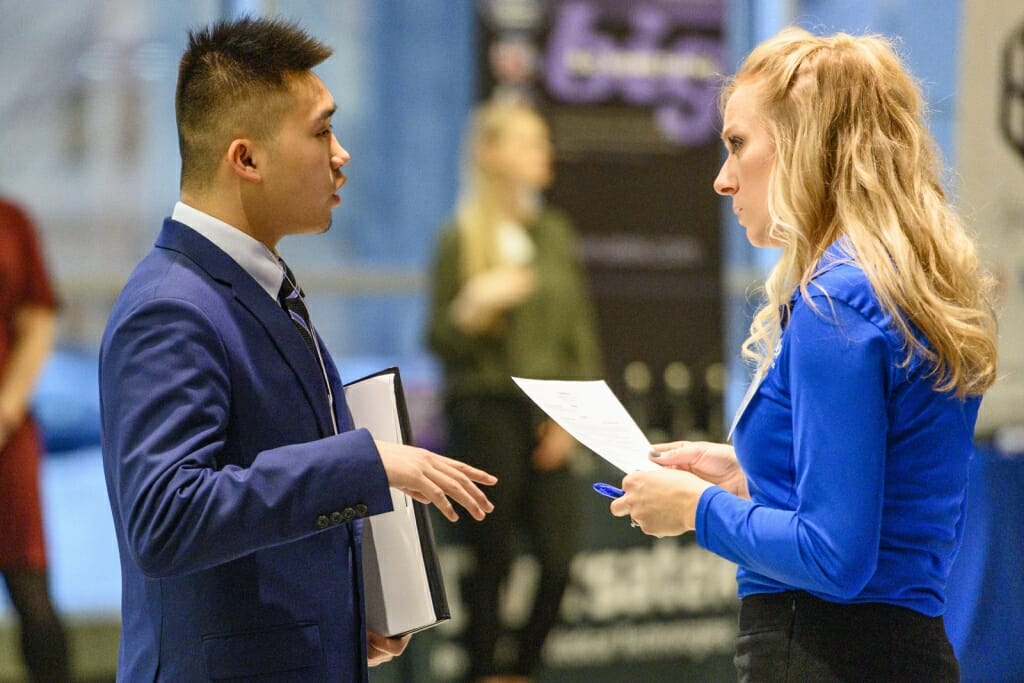 UW undergraduate Alvin Lee (left) talks with a recruiter.