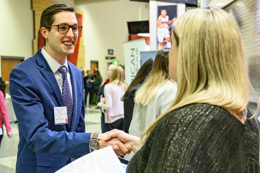 UW undergraduate Karsten Acker (left) talks with a recruiter from Yelp.