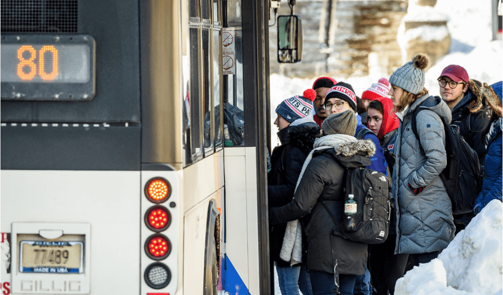 UW students bundle up to stay warm as they wait to board the #80 bus as temperatures hover around zero degrees Fahrenheit.