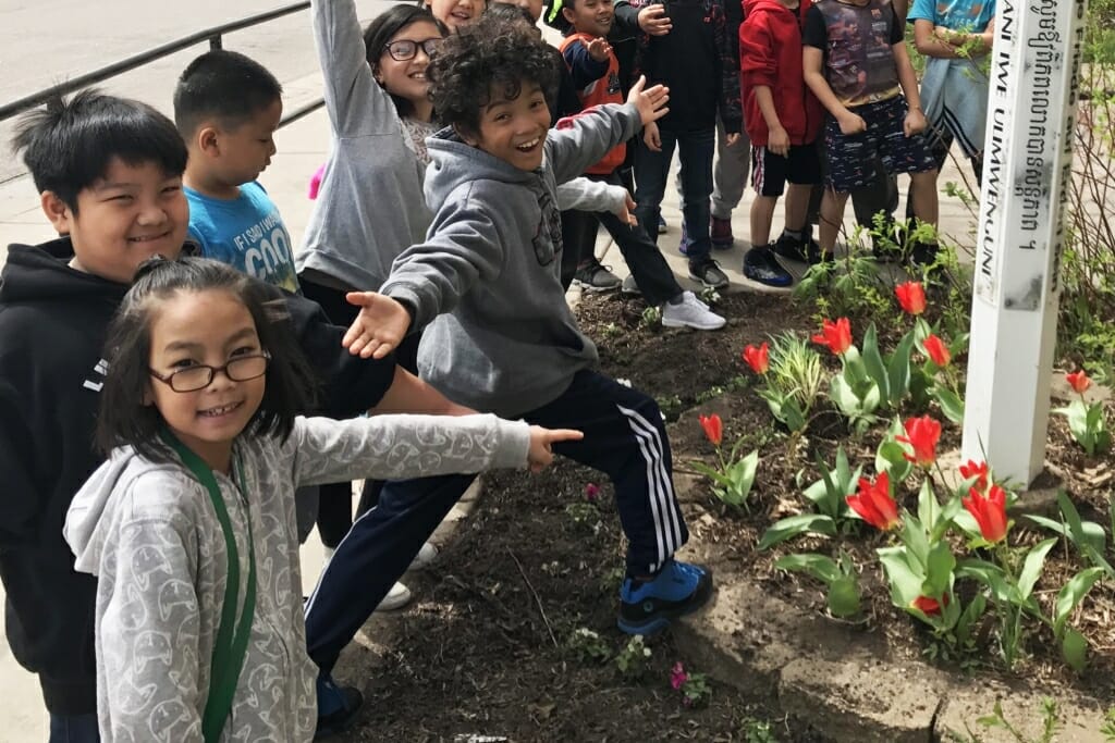 Photo: Children gesturing toward tulips