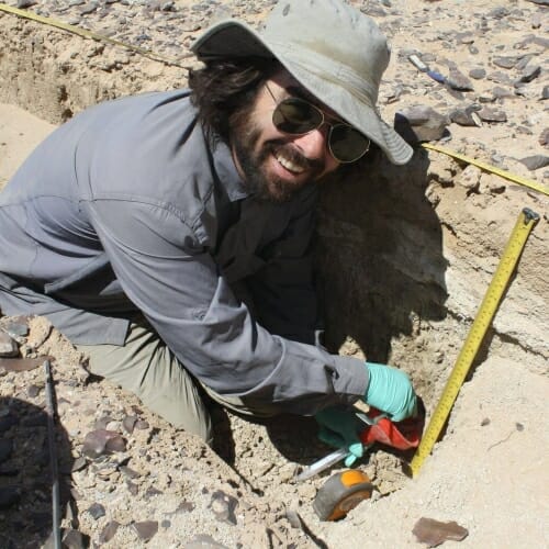 Photo: A man digging at an archeological site.