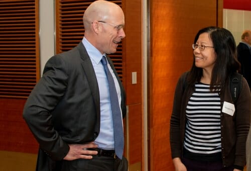 Photo: Jon Young, hands on hips, talks to a professor.