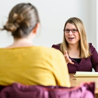 Photo: Kristin Shutts seated at table across from student