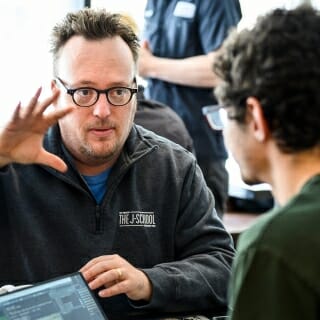 Photo: Michael Wagner seating and gesturing to student sitting across table