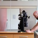 Photo of Morgridge Postdoctoral Fellow Rory Power inspecting the first iteration of the Flamingo microscope, which at a little over 40 pounds can be mailed to biology labs around the globe.