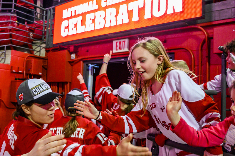 Photo of girl high-fiving a player.