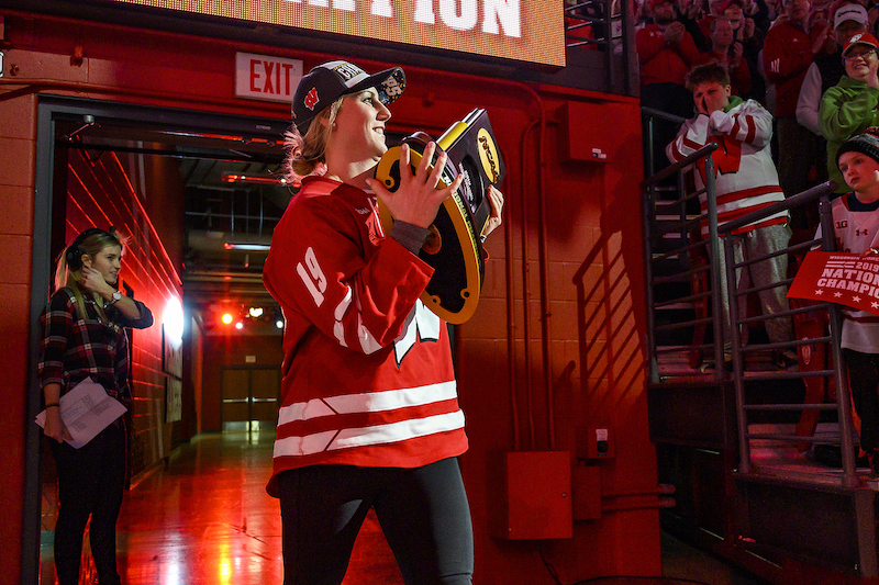 Photo of forward Annie Pankowski carrying the trophy.