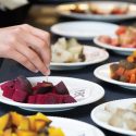 Photo: Plates full of different colored beets on a table.