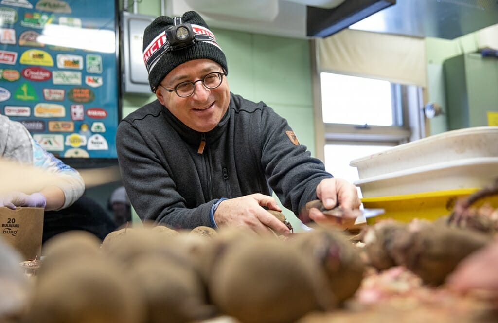 Photo: A man chops up beets.