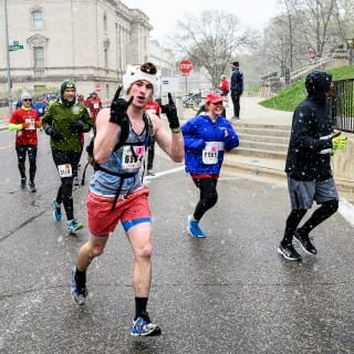 Photo: Runners scamper through the snow on wet cement near Science Hall.