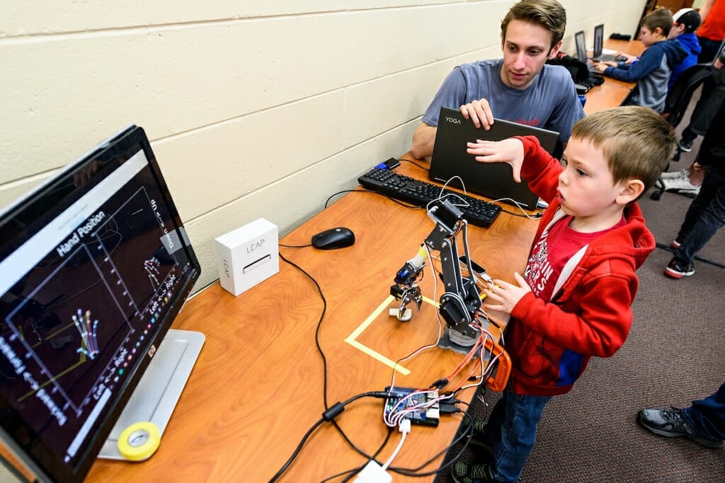 Photo: A college student watches as a boy moves his hand.