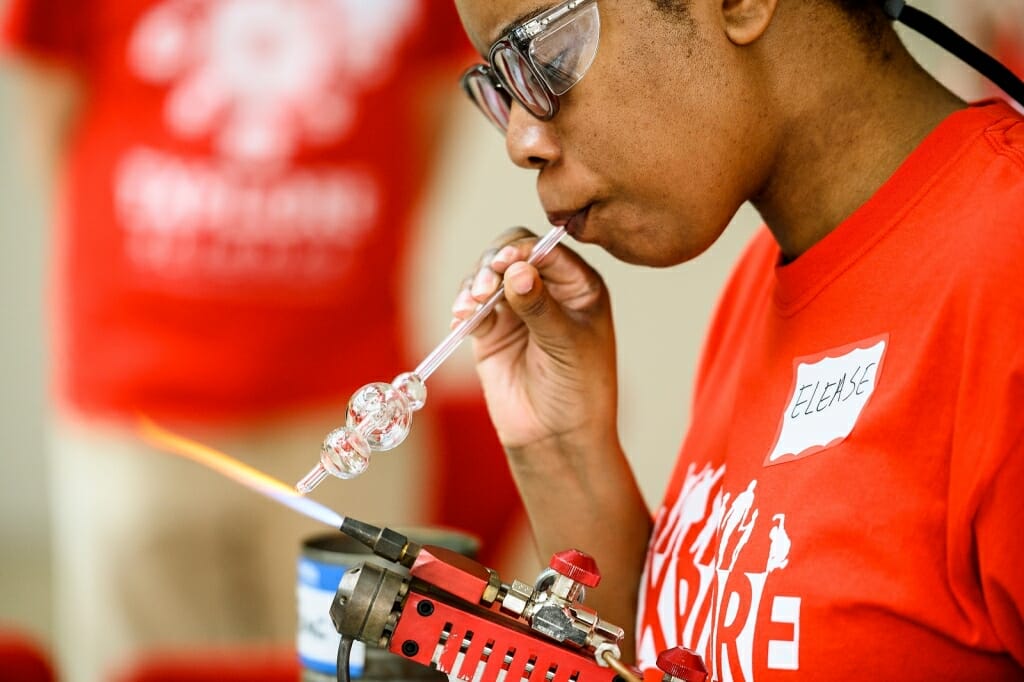 Photo of graduate student Elease McLaurin shaping a sample of scientific glassware