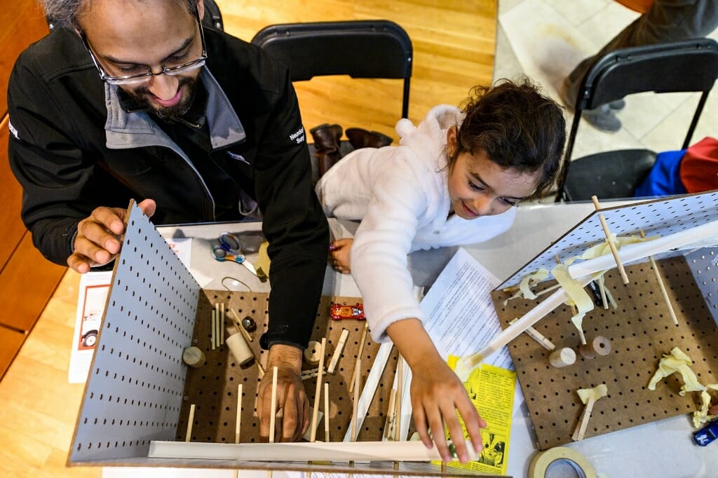 Photo of a father and daughter building a contraption.