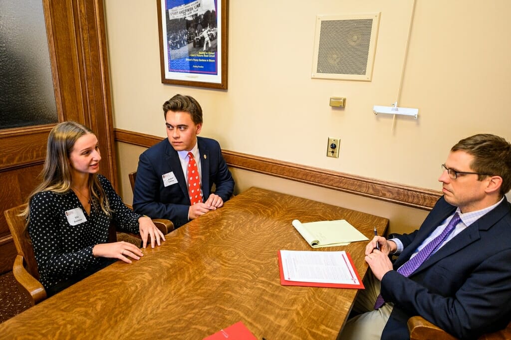 Photo: Students and aide seated at table