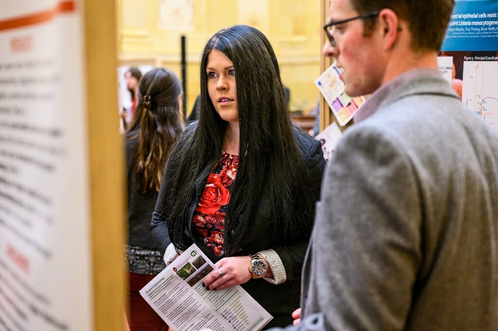 Jacqueline Adamicki, legislative aide to Representative Cindi Duchow, listens as  graduate student Paul Rowley presents information about his radiology research.