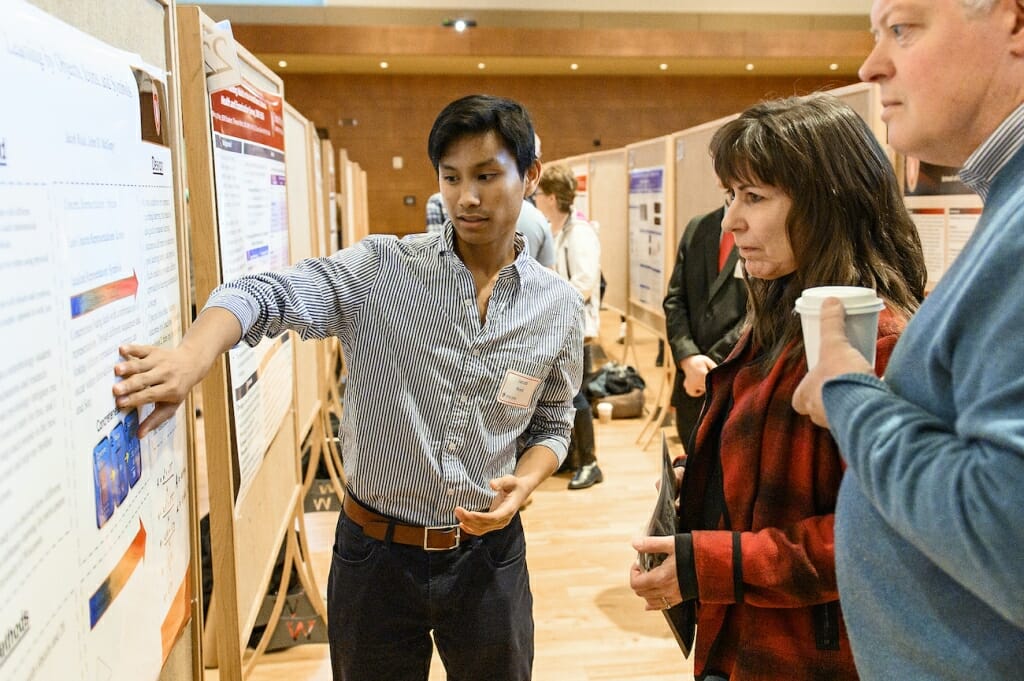 Photo: A student gesticulates as he explains his research.