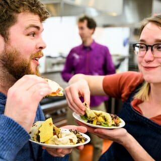 Photo: Two people dig into bowls of food.