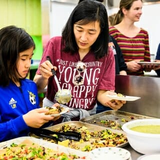 Photo: A woman and her daughter taste food.