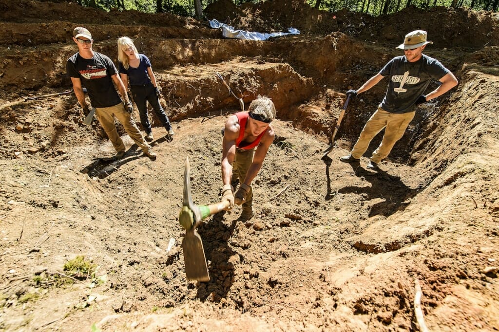 Photo: Man digging with pickaxe