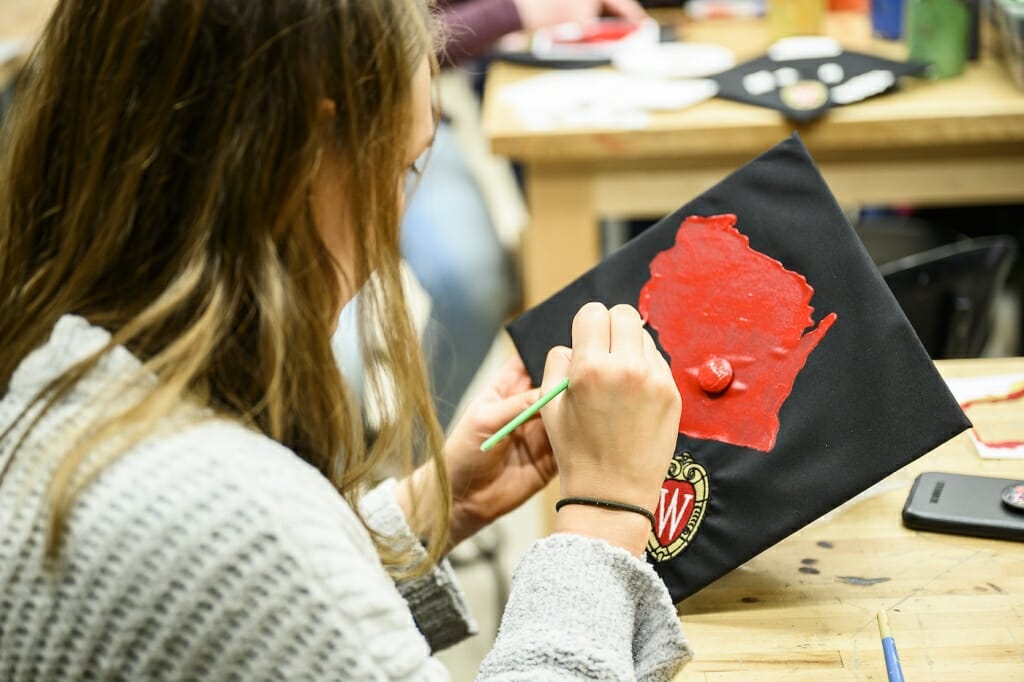 Photo: A woman decorates her mortarboard cap.