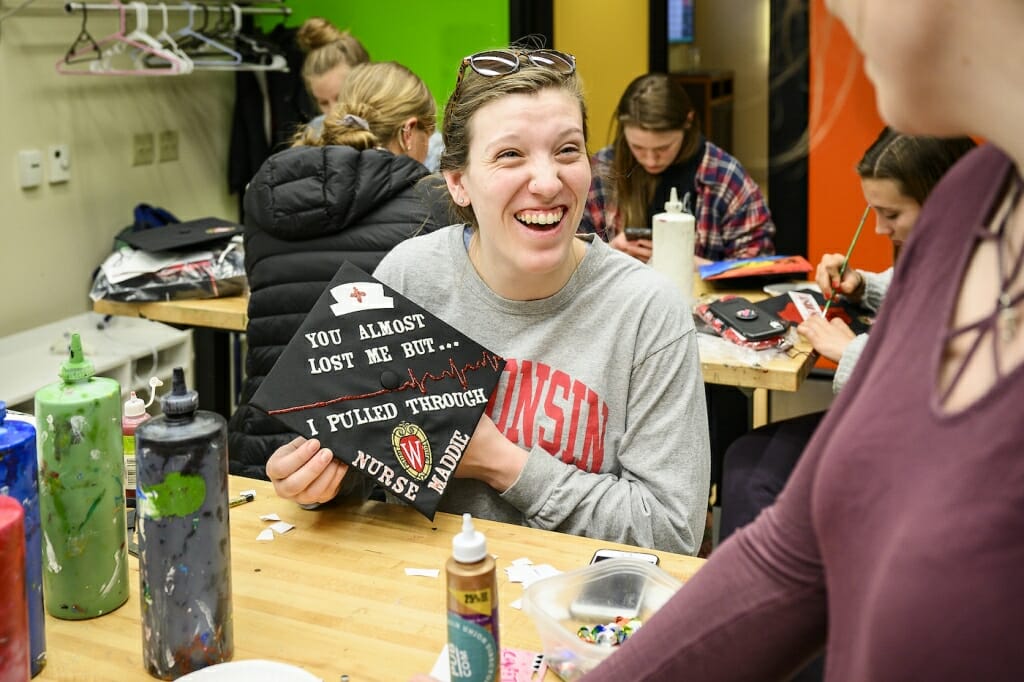 Photo: A woman holds up a decorated cap.