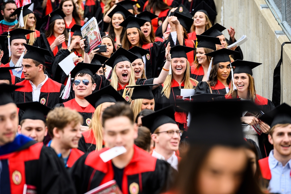 Photo of a crowd of graduates entering the stadium.