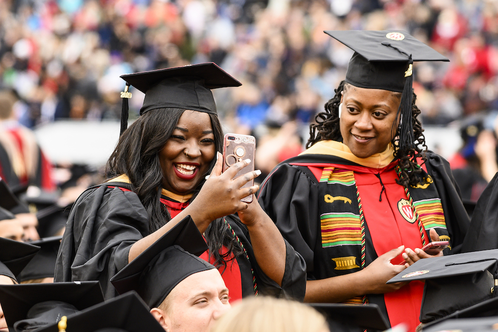 Photo of a graduate video chatting on her phone.