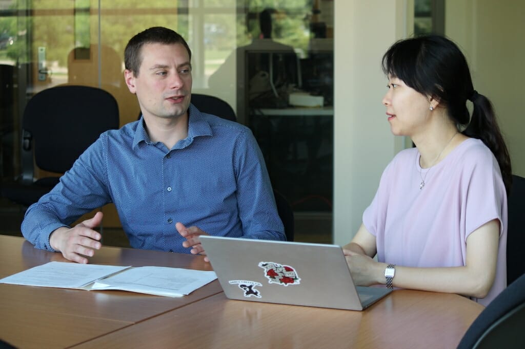 Photo: A man and a woman talk at a table.