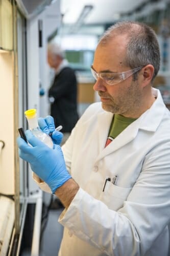 Photo: A man labels a bottle.