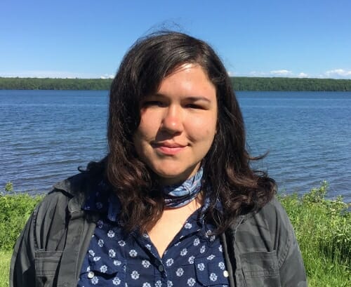 Photo: Portrait of Sarah standing in front of water