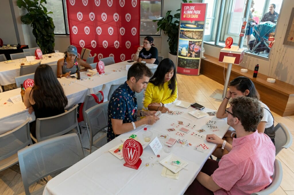 Photo: People sit around a table playing cards.