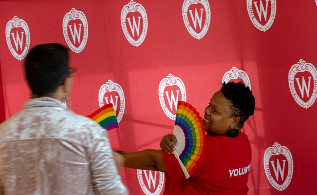 Photo: A woman holds a fan and poses for a photographer.