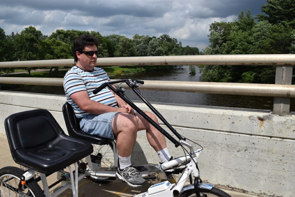 Photo: A man sits on a bike on a bridge.