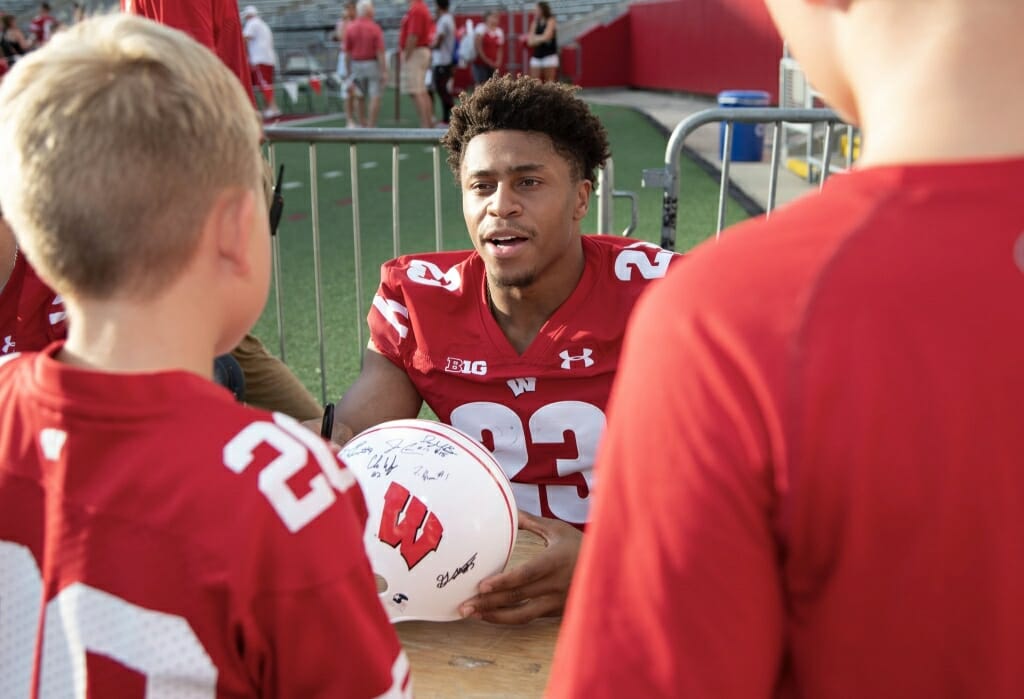 Player Jonathan Taylor signs a helmet.