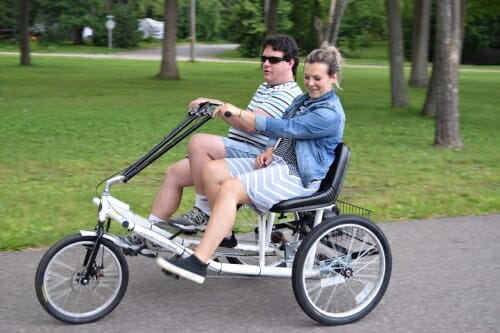 Photo: Two people side by a side on a three-wheel bike.