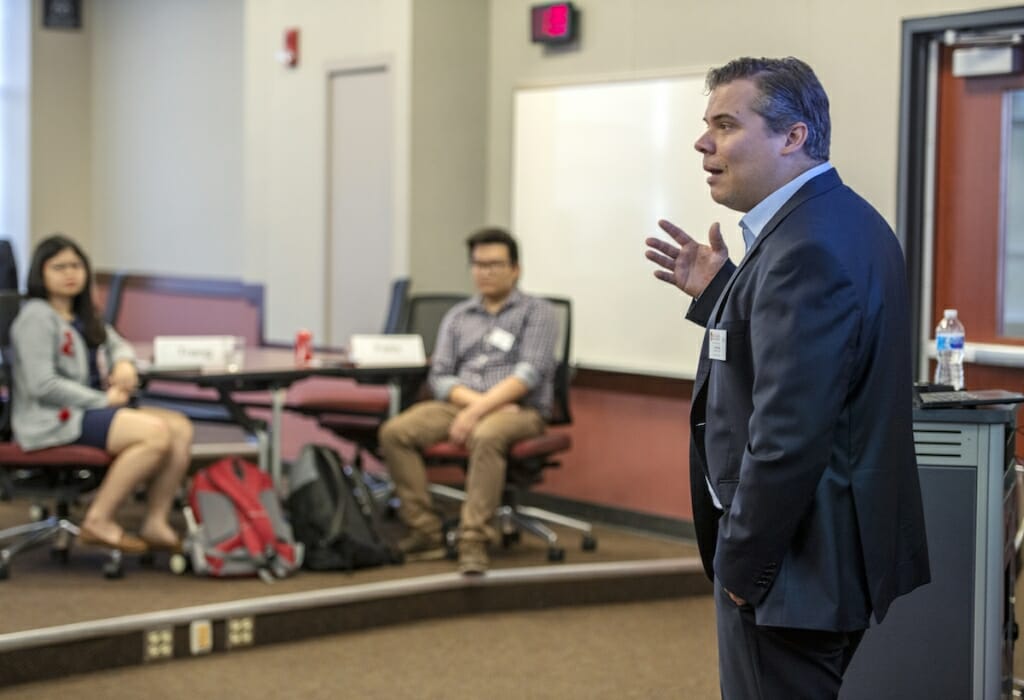 Photo: A man speaks to a room full of students.