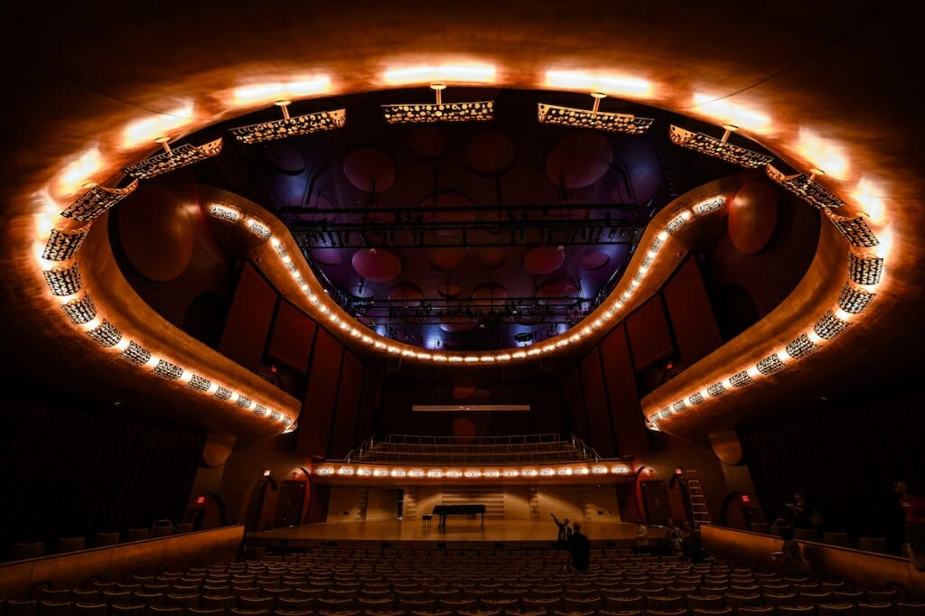 Photo: Inside of dark concert hall with lights on ceiling