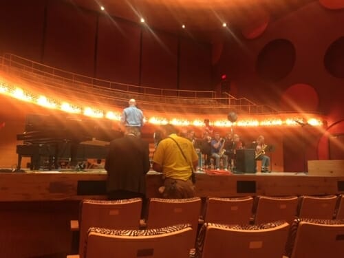 Photo: Talaske standing on stage with musicians