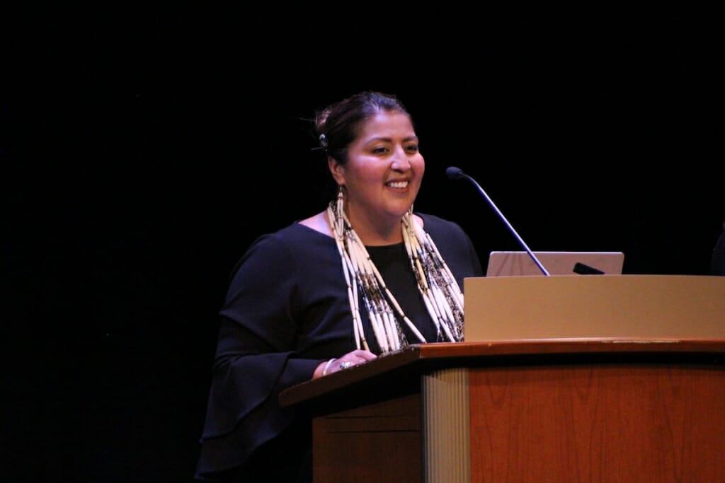 Photo: A woman speaks at a podium.