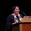 Photo: A woman speaks at a podium.