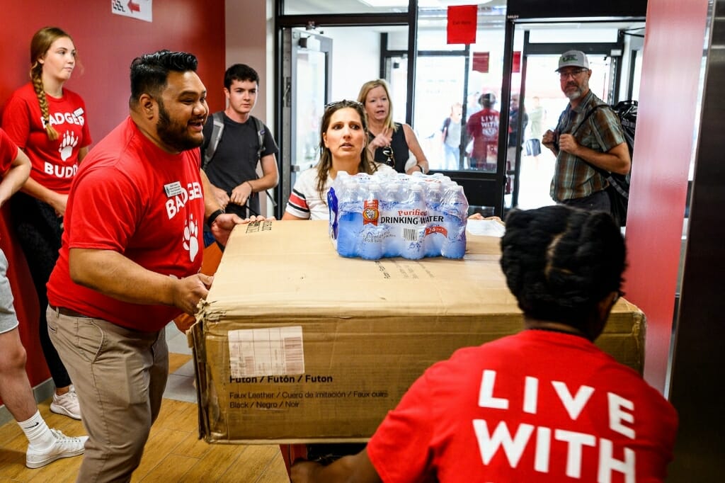 Photo of Gabe Javier helping students steer their belongings to an elevator.