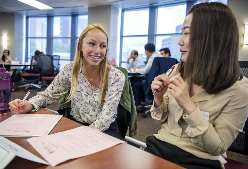 Photo: Two students talk to each other.