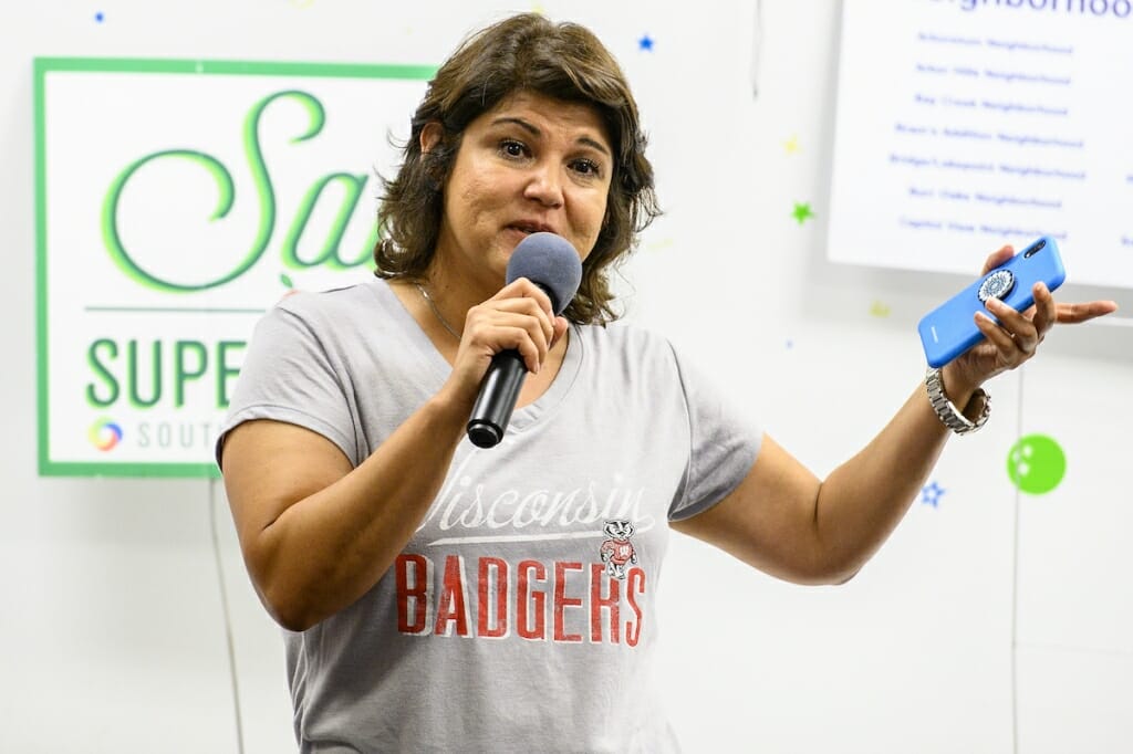 Photo: A woman addresses a room of visitors.