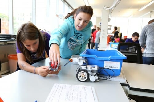 Photo: 2 people holding a small robot part