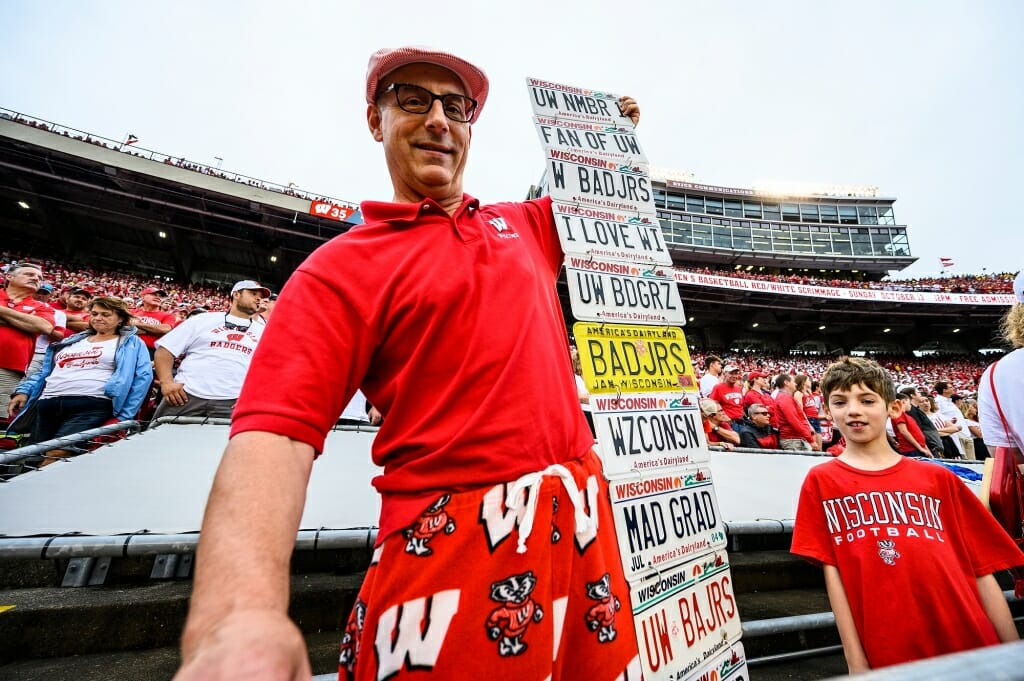 Photo: A man displays a dozen Badger-themed license plates.