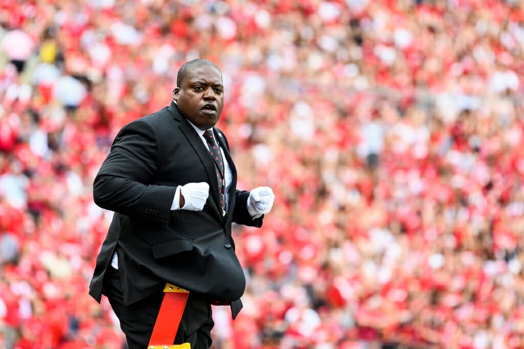 Photo: Pompey in dark suit and white gloves standing on ladder in stadium