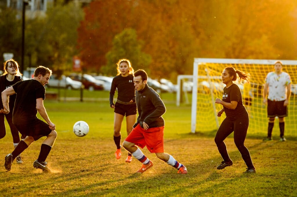 Photo: Soccer players run as the sun sets.