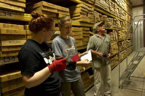 Photo: Three researchers in a warehouse.