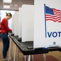 Photo: Closeup of American Flag VOTE sign on a polling booth